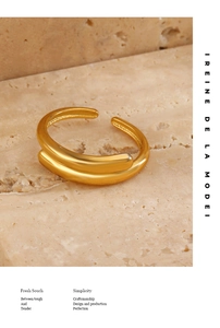 Detail of minimalist 18K gold plated double line open ring on stone texture background