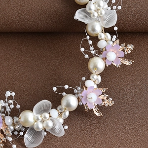 Macro detail of bridal headband with handmade pearls, crystals, and gold leaf weaving