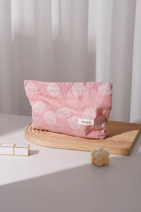 Detail of pink cotton linen makeup bag with white leaf embroidery and H&R BAG woven label