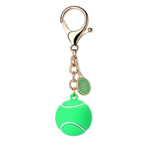 Green silicone tennis ball and golden racket keychain set on a clean white background