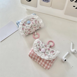 Close-up of lace-trimmed fabric earphone cases with floral patterns and pink hanging hooks