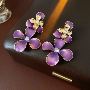Detail of purple gradient enamel flower earrings with gold edges and central zircon