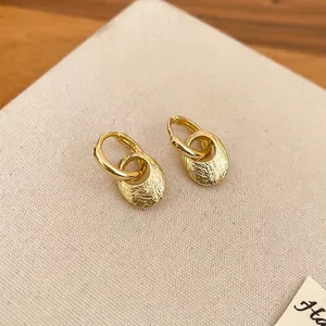 Minimalist gold oval earrings with textured metallic finish and double hoop design