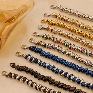 Close-up of spiral titanium steel bracelets in gold silver and rainbow colors on silk