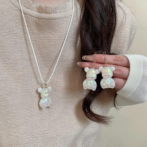 Detail of colorful resin bear necklace and earrings set with iridescent finish