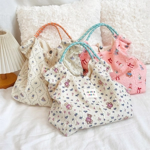 Detail of embossed bubble fabric tote bags with teddy bear prints and woven rope handles