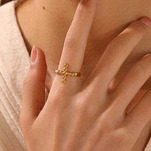 Verstellbarer goldener Edelstahl-Kreuzring im Boho-Stil an einer weiblichen Hand getragen