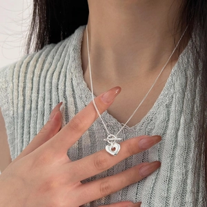 Close-up of S925 sterling silver OT buckle necklace with hollow heart pendant on model