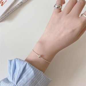 Minimalist S925 sterling silver beaded bracelet and ring set shown on a book background