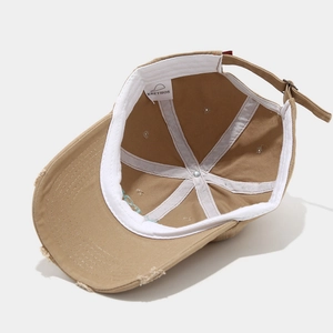 Detailed interior of a khaki distressed baseball cap showing seams and inner sweatband