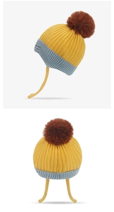 Detail of yellow kids knit beanie with grey ribbed brim and brown faux fur pom-pom