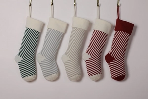 Detail of five hanging knitted Christmas stockings with various colorful striped patterns