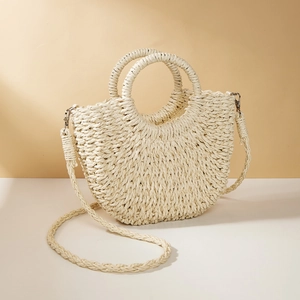 Detail of half-moon woven straw bag with circular handles and silver metal D-ring buckle