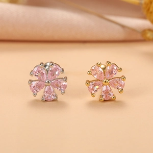 Gros plan de boucles d'oreilles en cœur avec zircons roses et montures en or et argent