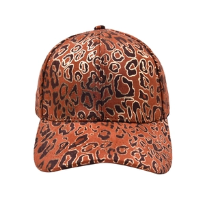 Macro detail of high-quality leopard print fabric and golden glitter accents on baseball cap