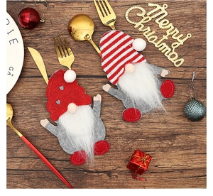 Close-up of Gnome Christmas cutlery holders on a vintage wood table with holiday decor