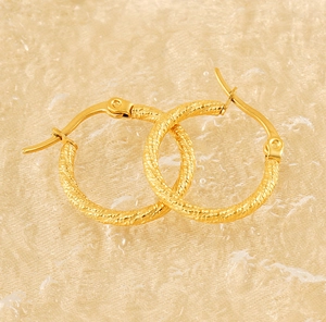 Detailed view of gold plated twisted hoop earrings with textured spiral design and latch