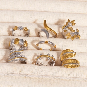 Detail of mixed gold and silver rings set featuring leaf and feather motifs in a display box
