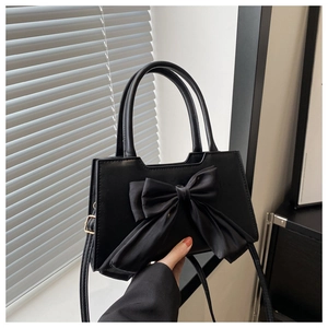 Detail of black crossbody handbag with large satin bow and French vintage aesthetic