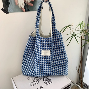 Close-up of blue and white checkered woven tote bag showing thick fabric texture