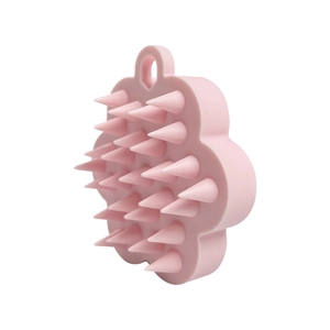Pink flower-shaped silicone hair scalp massager and shampoo brush on white background