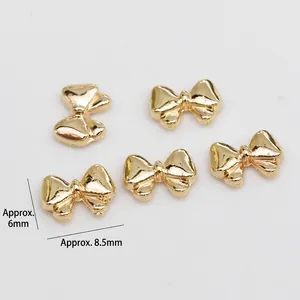Detailed view of 5pcs gold bow nail art charms made of alloy for DIY jewelry decor