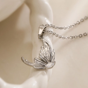 Minimalist silver butterfly pendant necklace with sparkling cubic zirconia on ceramic base