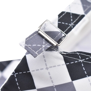 Detail of silver metal adjustment buckle on black and white diamond pattern cotton strap