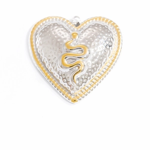 Detailed close-up of heart-shaped pendant with gold snake relief and silver hammered texture