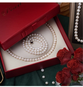 Detail of round natural freshwater pearl necklace in a premium red jewelry gift box