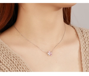Close-up of pink and white cherry blossom zircon pendant on a silver necklace for women