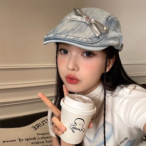 Light blue denim beret hat for women with silver bow decoration in lifestyle setting