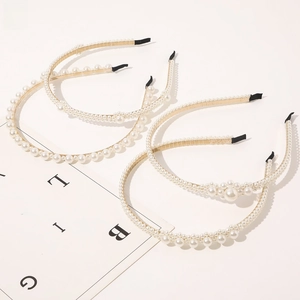 Detail view of four elegant gold metal pearl headbands with various bead sizes