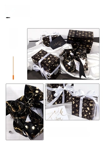 Detail of black and gold foil gift wrap set with heart, crown patterns and ribbons