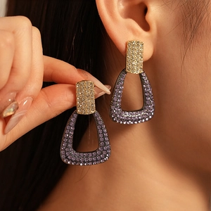 Elegant geometric earrings with purple rhinestones and cubic zirconia in golden finish