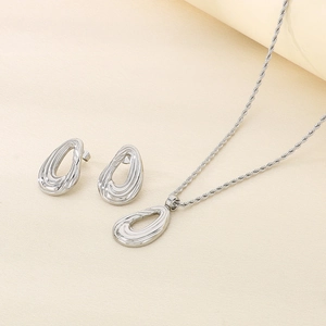 Silver teardrop necklace and earrings set with twist rope chain on minimal background