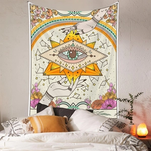 Detail of bohemian tapestry with mystic eye and hands pattern above a bed