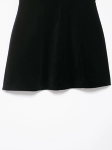 Détail du tissu en velours doux et de l'ourlet à volants de la mini-robe noire élégante