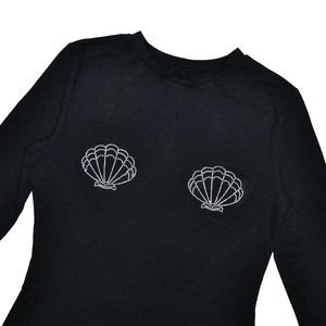 Detail shot of black long sleeve slim top with sparkling rhinestone shell pattern on chest
