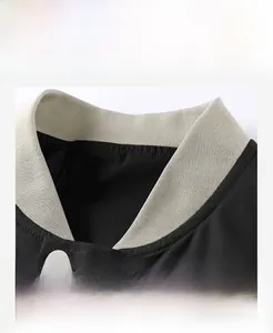Close-up of baseball jacket ribbed collar with premium textured fabric and white snap button