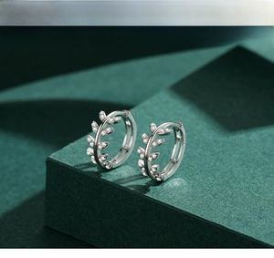Vue macro de boucles d'oreilles feuilles en argent S925 avec zircons scintillants