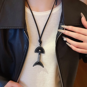 Chic fishbone pendant necklace with black leather and silver metal on a model outfit
