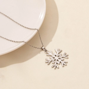 Close-up of polished silver snowflake pendant on a delicate stainless steel O-chain
