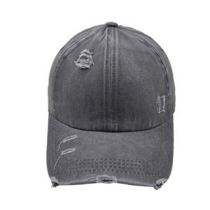 Detailed macro view of charcoal grey washed cotton baseball cap with distressed hole texture