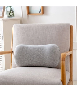 Close-up of a grey memory foam lumbar pillow on a modern grey armchair in a cozy home