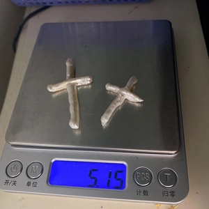 Macro shot of two cross-shaped baroque freshwater pearls on a digital scale for weighing