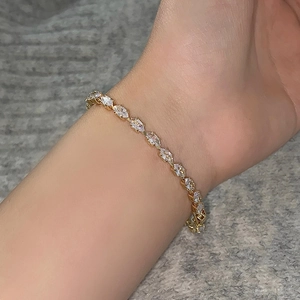 Detail of marquise-cut crystal bracelet in gold plating worn on woman wrist