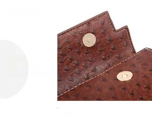Detail of ostrich leather texture and magnetic closure on brown shoulder bag with stitching
