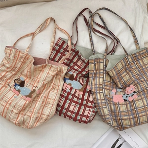 Detailed view of plaid canvas tote bags with cute cartoon animal embroidery and soft handles