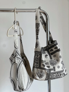 Close-up of cotton linen tote bags featuring paisley and wave patterns on hangers